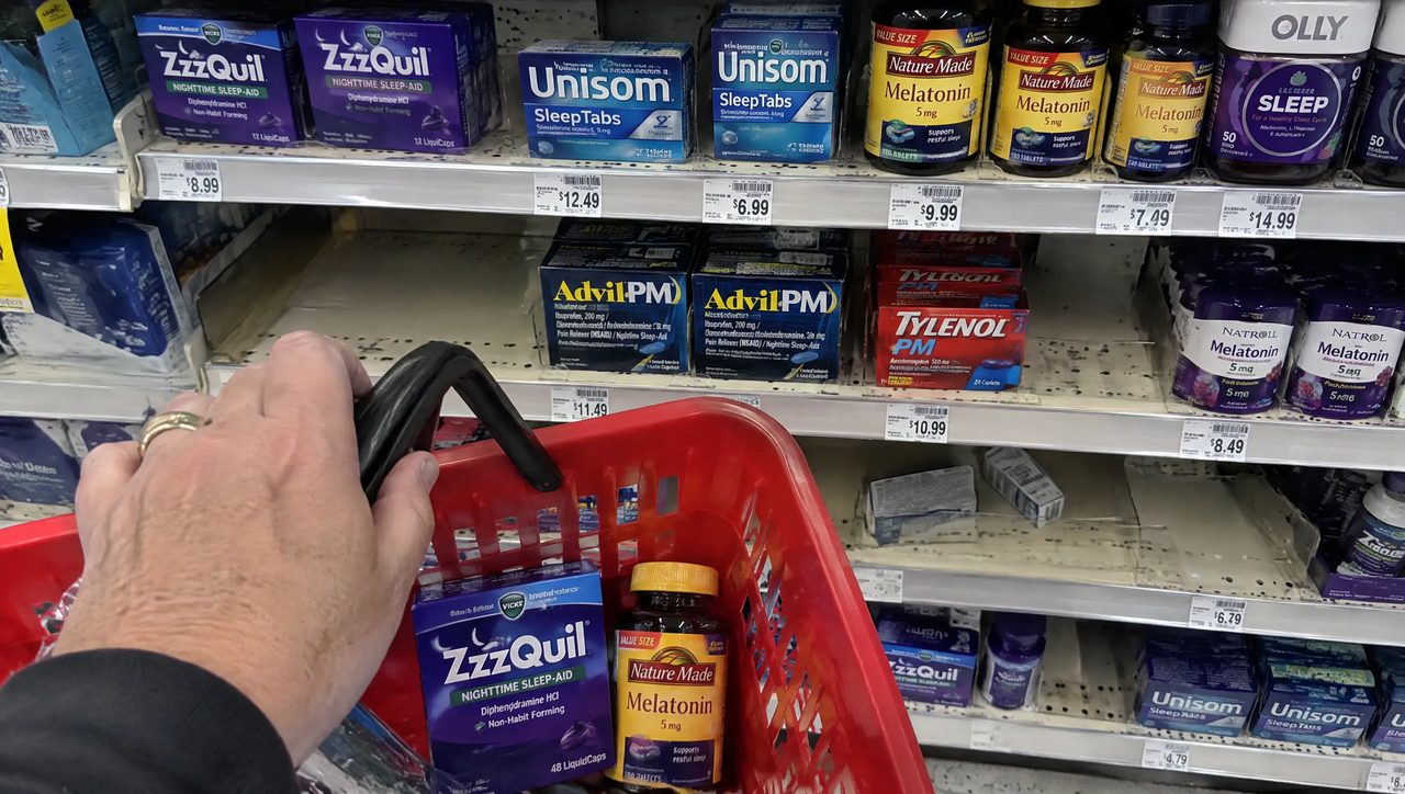 Drugstore aisle packed with sleep aids and a basket already holding two of them