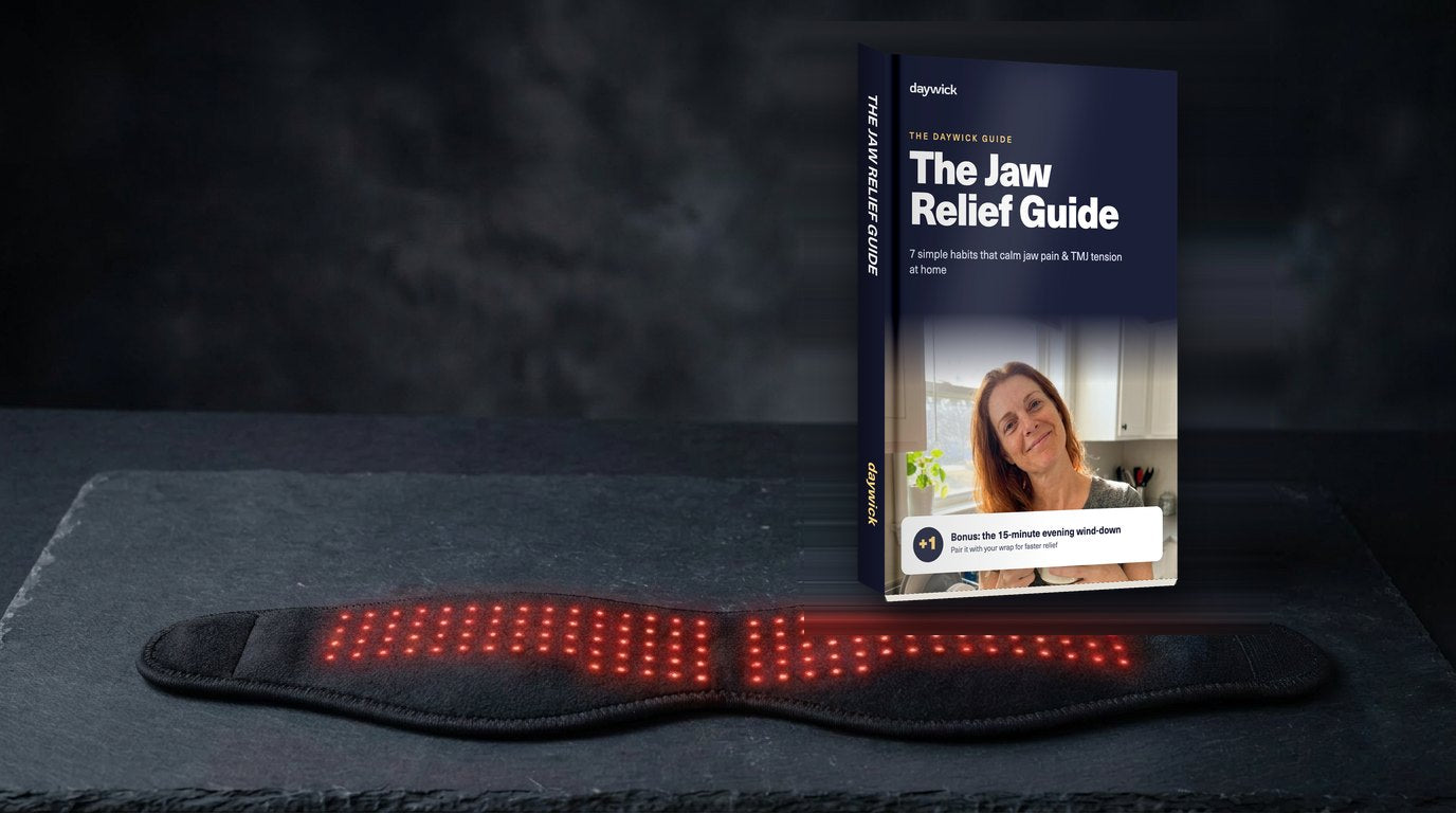 The Daywick TMJ Therapy Wrap with its red lights on, its box and the Jaw Relief Guide